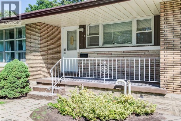 Close-up of the front entrance with a white door, railing, and stone steps. - 139 Elgin Crescent, Waterloo