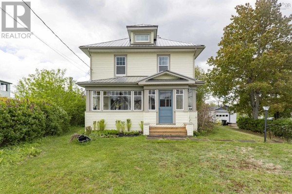View of the front porch from the doorway, showing wicker chairs and a rug. - 139 Main Street, Springhill