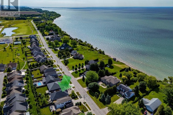 Aerial view of a suburban neighborhood with houses lining a street near a large body of water. - 139 New Lakeshore Road, Norfolk