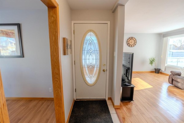 Entryway with decorative door, hardwood flooring, and a view into the living area - 1392 Ravelston Avenue, Winnipeg