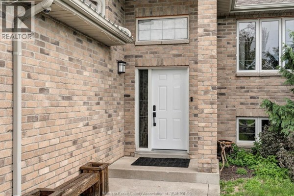 Front entrance of a brick house with a white door, sidelight window, and concrete steps. - 1397 Crosswinds Drive, Lakeshore
