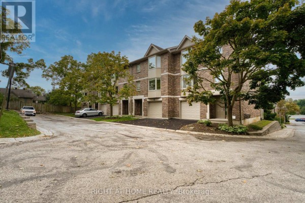 View of townhouses and surrounding trees from a curved driveway. - 14 - 1548 Richmond Street, London North