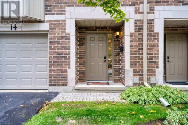 Front door entrance of townhouse unit 14 with a garage door. - 14 - 1548 Richmond Street, London North