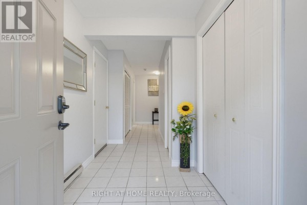 Interior view of a hallway with tiled floors and white doors. - 14 - 1548 Richmond Street, London North