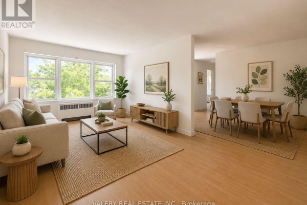 Living room with sofa, armchair, coffee table, and large window overlooking trees. - 14 - 917 Hamilton Road, London East