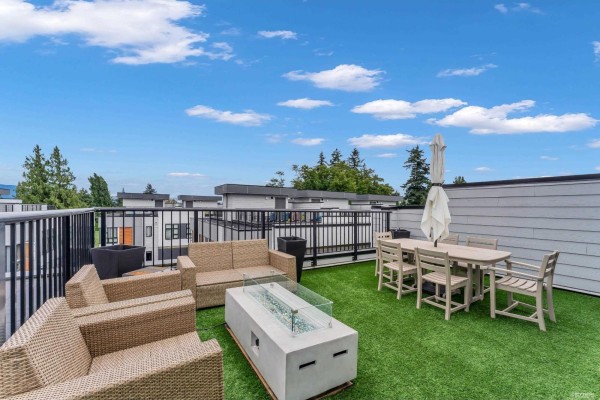 Exterior view of a townhouse complex featuring grey siding, wood accents, and multiple windows. - 14 1419 Mccallum Road, Abbotsford