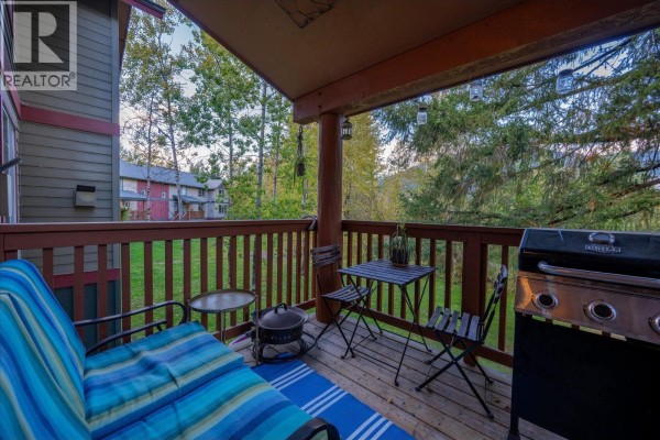 Deck with a grill, patio furniture, and view of trees and distant buildings. - 14 1450 Vine Road Road, Pemberton