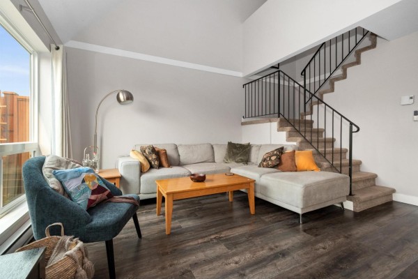 Living room with a sectional sofa, coffee table, and stairs to the upper level. - 14 1829 Heath Road, Agassiz, Agassiz