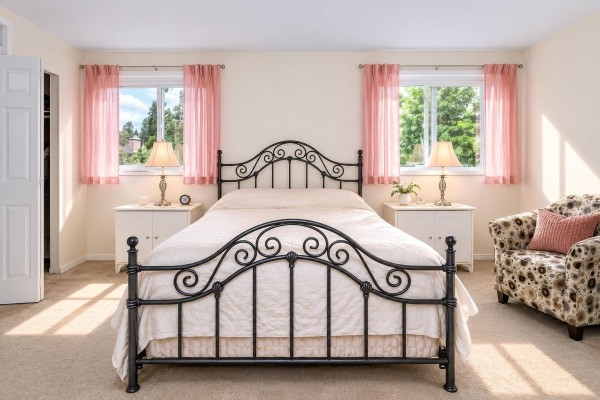 Bedroom with queen bed, white nightstands, armchair, and pink curtains on windows. - 14 32165 7th Avenue, Mission