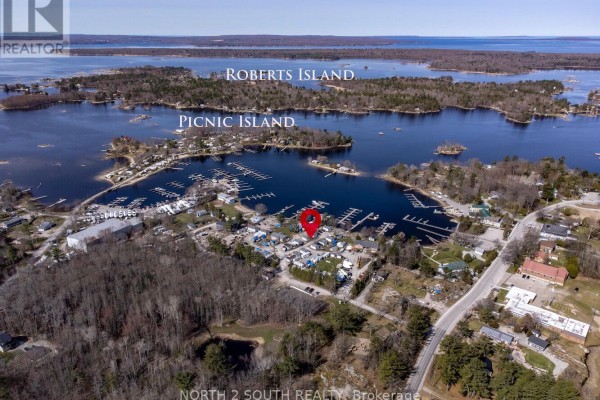 Aerial view of Georgian Bay waterfront showing marina, Roberts Island, Picnic Island, and wooded land. - 14-42 Bluewater Road, Georgian Bay
