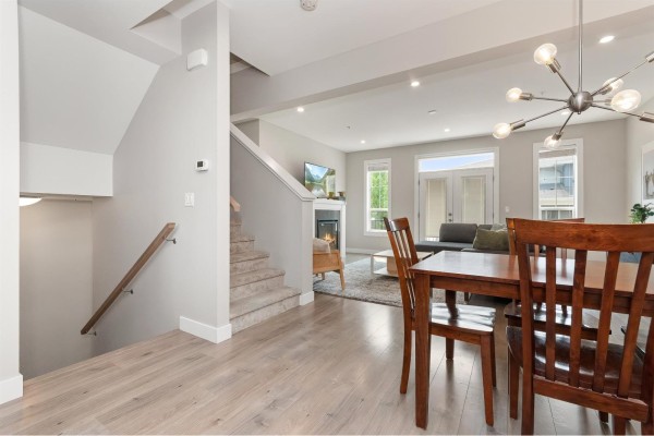 Open concept dining and living area with wood floors, fireplace, and large windows. - 14 45545 Kipp Avenue, Chilliwack Proper West, Chilliwack