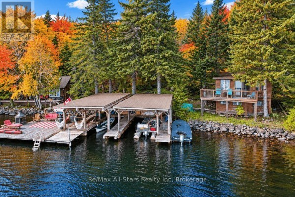 Blue floating mat on a calm lake surrounded by evergreen and autumn-colored trees. - 14 60 Highway E, South Algonquin