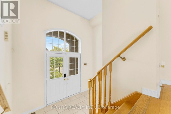 View of the home's foyer with double doors featuring a large arched window above. - 14 Arrowstone Court, Brampton