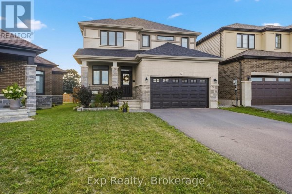 Front exterior of a two-story house with a dark grey garage door and beige brick. - 14 Athabaska Drive, Belleville