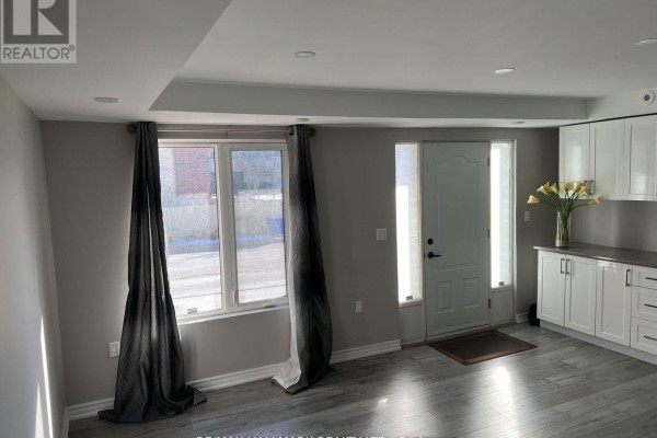 Open concept living space with grey floors, white cabinets, and a white door. - 14 #basement - 3029 Finch Avenue W, Toronto
