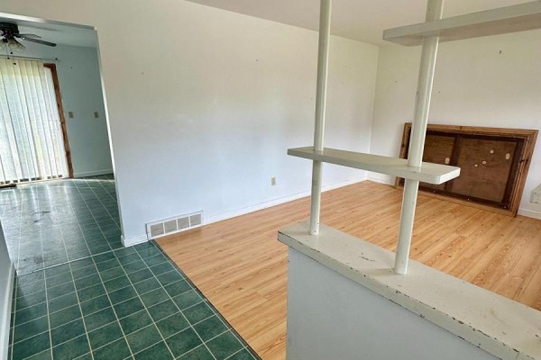 Interior view showing a transition from light wood laminate flooring to green tile flooring. - 14 Brock Crescent, Collingwood