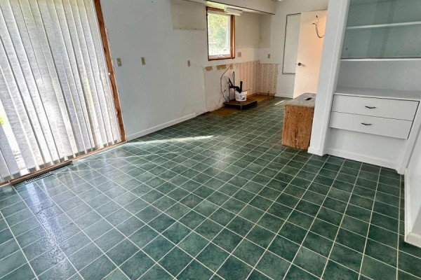 Room with green tile flooring, sliding glass doors, and built-in shelving. - 14 Brock Crescent, Collingwood