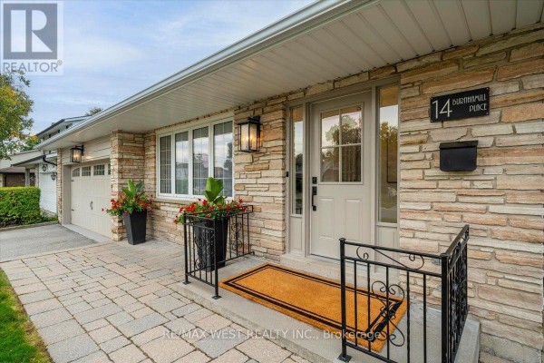 Close-up of the front entrance with stone facade, light beige door, and window. - 14 Burnhamill Place, Toronto