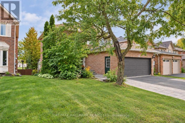 Side exterior view of a brick house showing the garage and a small side door. - 14 Crawford Rose Drive, Aurora
