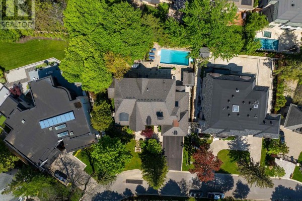 Swimming pool area with stone patio, wooden fence, and water feature. - 14 Denewood Crescent, Toronto