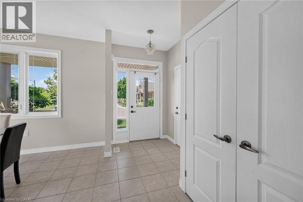 Interior view of a room with tiled floors, white double doors, and a window looking out to the front entrance. - 14 Ecker Lane, Binbrook
