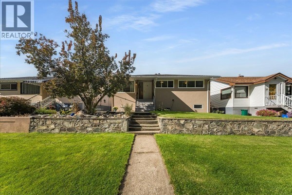 Front view of a beige residential house with a paved walkway leading to the entrance. - 14 Hillside Drive, Trail