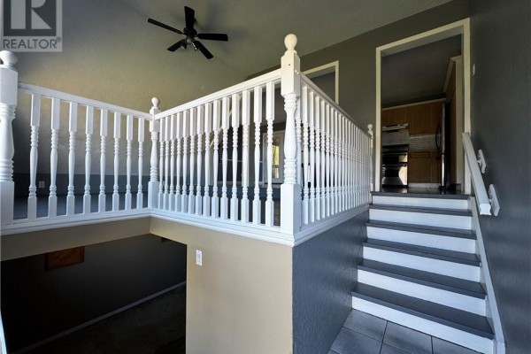 Interior staircase with white spindles and grey walls, leading upstairs and down. - 14 Lynne Court, Chapleau