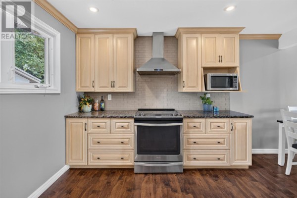 Kitchen with light wood cabinets, granite countertops, stainless steel stove, and beige tiled backsplash. - 14 O'regan Road, St  John S