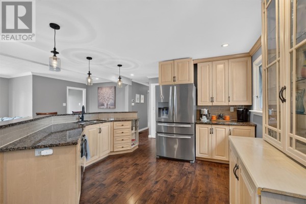 Open-concept kitchen with light wood cabinets, granite countertops, stainless steel appliances, and hardwood floors. - 14 O'regan Road, St  John S