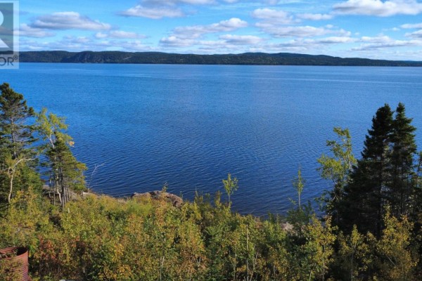 Panoramic view of a calm blue lake with tree-covered hills in the distance. - 14 Old Country Road, Point Of Bay