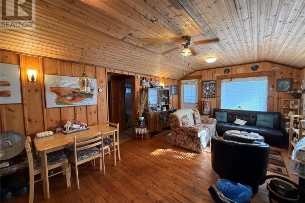 Interior living and dining area with wood-paneled walls, wood floors, and furniture. - 14 Old Country Road, Point Of Bay