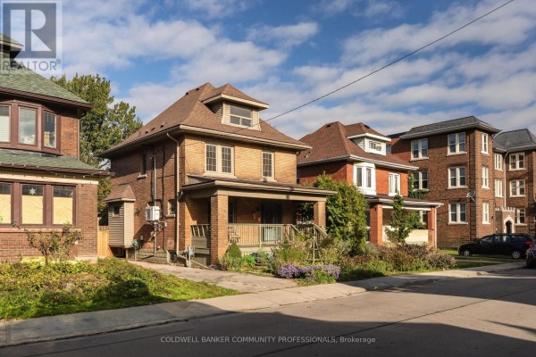 Exterior view of a brick house with a covered front porch and landscaping. - 14 Prospect Street S, Hamilton