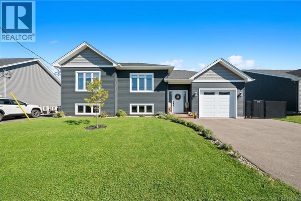 Front view of a dark grey siding house with a well-kept lawn and driveway. - 14 Robert Street, Shediac