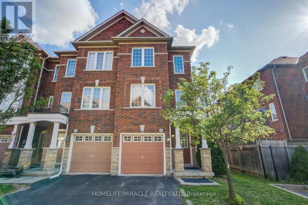 Hallway inside the townhouse with white doors, cream walls, tile flooring, and artwork. - 14 Rock Haven Lane, Brampton