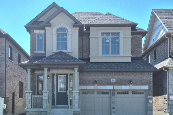 The front facade of the house features brick and stucco with a prominent arched window. - 14 Rogerson Street, Clarington