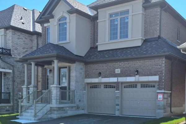 Close-up of the double garage doors and brick exterior of the home. - 14 Rogerson Street, Clarington