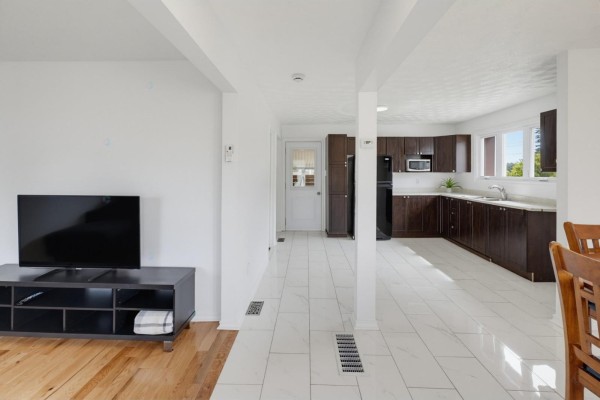 Open kitchen area with dark cabinetry, appliances, and adjacent dining space - 14 Rue Michaud, Gatineau