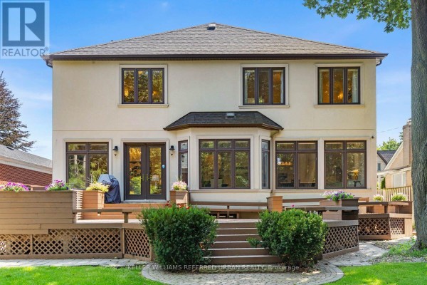 Spacious white kitchen with stainless steel appliances, a large island, and wood floors. - 14 Tremont Crescent, Toronto