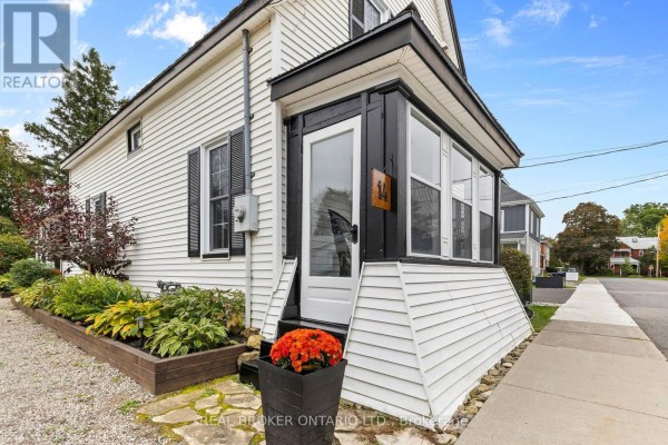 Close-up of the front entrance with a white door and a screened-in sunroom. - 14 Victoria Avenue, North Grenville