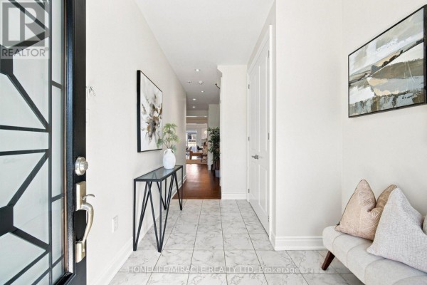 Modern hallway with marble tile, console table, art, and bench - 14 Zenith Avenue Vaughan