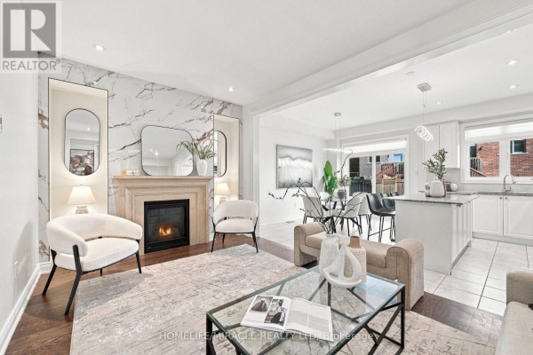 Living room with fireplace and marble wall, opening to the dining area and kitchen. - 14 Zenith Avenue, Vaughan