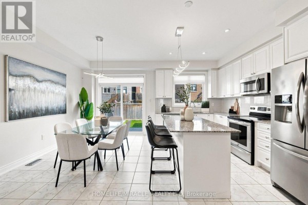 Kitchen and dining area with stainless steel appliances, granite countertops, and a glass dining table. - 14 Zenith Avenue, Vaughan