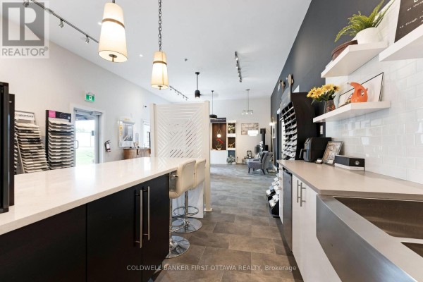 Interior view of a commercial space with white subway tile backsplash, sink, and white cabinets. - 140 Industrial Avenue, Carleton Place