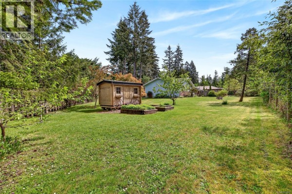 Open concept living and dining area with a kitchen view and wood ceiling. - 140 Quarry Dr, Salt Spring