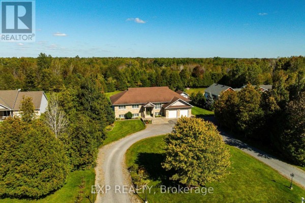 Aerial view of a house on a large lot surrounded by trees. - 140 Windmill Crescent, Beckwith