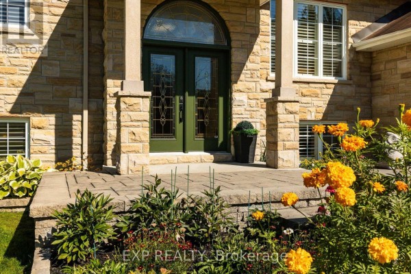 Close-up of the front entrance with green double doors and stone pillars. - 140 Windmill Crescent, Beckwith