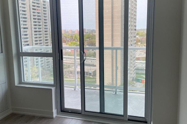 View from balcony with sliding glass doors and city buildings in the background. - 1401 - 10 Wilby Crescent, Toronto