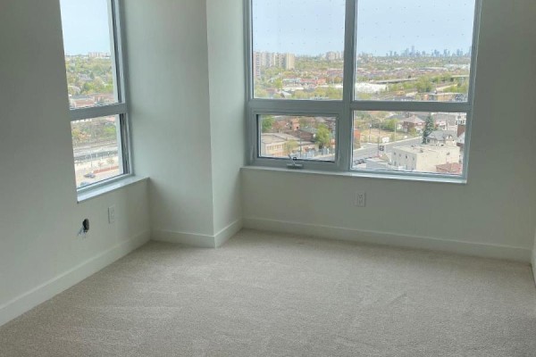 Bedroom with beige carpet and large windows overlooking the city. - 1401 - 10 Wilby Crescent, Toronto