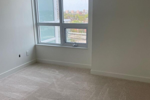 Bedroom corner with beige carpet and large windows with city view. - 1401 - 10 Wilby Crescent, Toronto