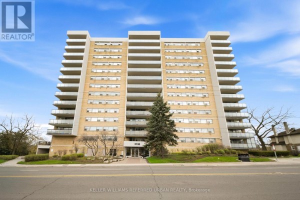 Exterior of a brick apartment building with balconies and trees in daylight. - 1401 - 2130 Weston Road, Toronto